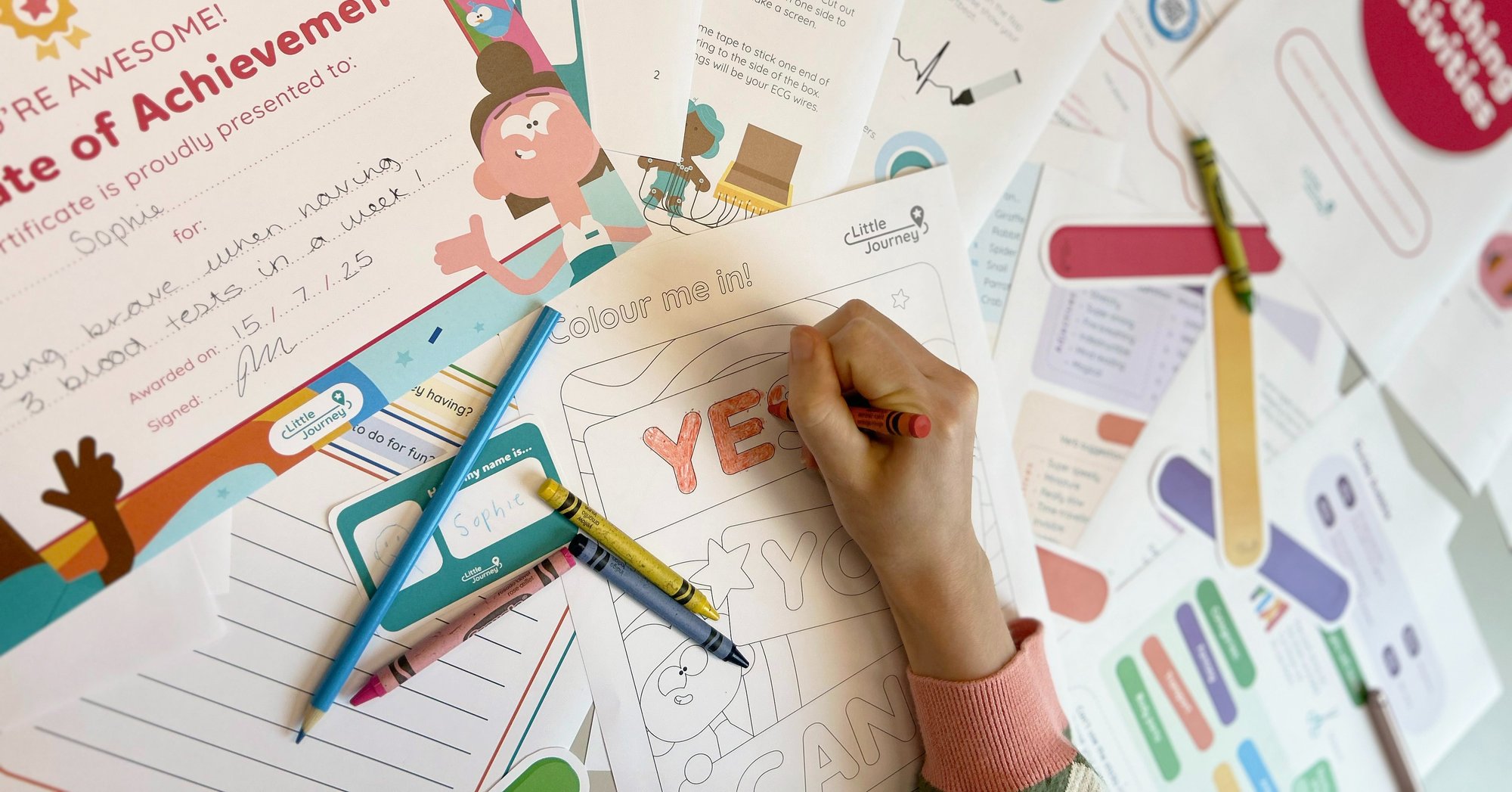 A person is colouring in, surrounded by activity sheets, crayons and pencils A person is colouring in, surrounded by activity sheets, crayons and pencils