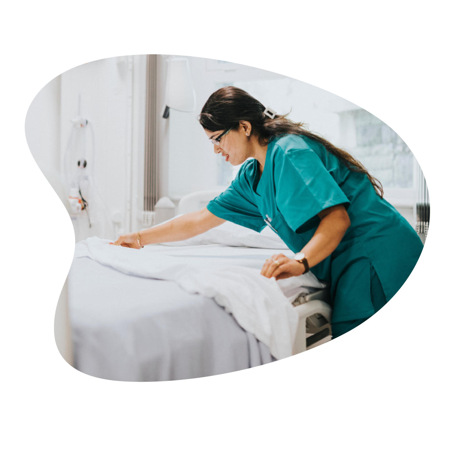 Member of hospital staff making a hospital bed